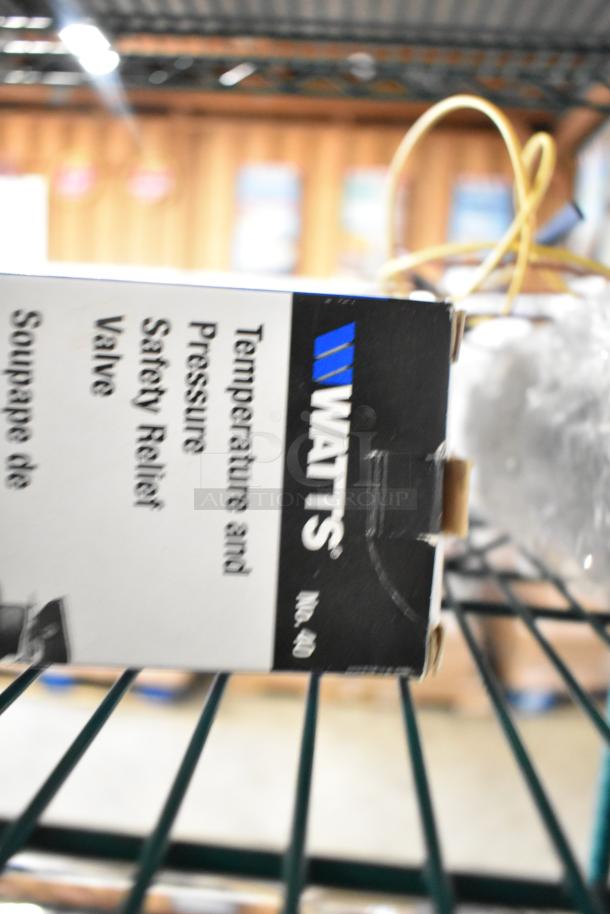Box of Watts Safety Relief Valve on wire shelf, partial focus.