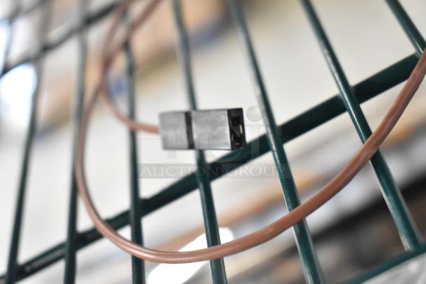 Coiled brown wire against a green metal grid; part of new scratch and dent auction items, including Delfield parts and Watts valve.