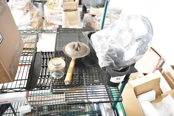 Alt text: Assorted items including glass jar with latch lid, cast iron pan with wooden handle, plastic bins, and vent cover.