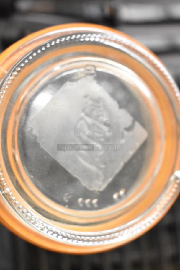 Glass jar with embossed logo on the bottom, part of a set featuring six diverse items including a jar, blade sharpener, bin, and ice vent cover.