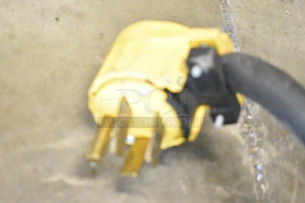 Blurry close-up of an electric plug, possibly for a 2016 Turbochef HhC2020 commercial oven.