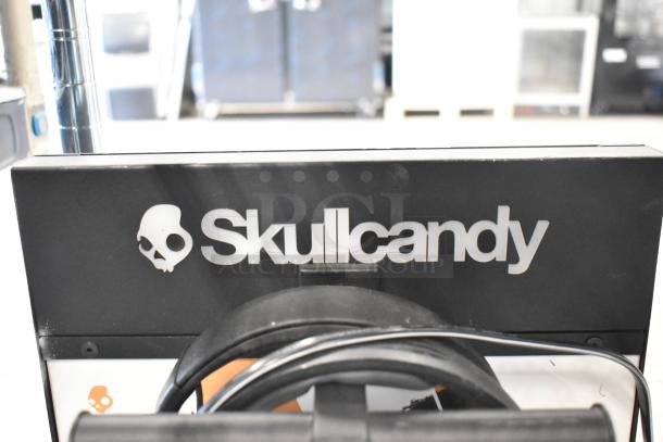 Various Skullcandy display with headphones. Branded stand, visible logo. Includes four displays in bid.