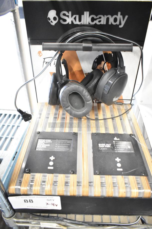 Skullcandy headphone display with over-ear headphones, brand signage, wood panel stand, functional controls visible, excellent condition.