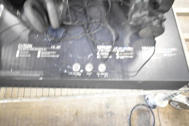 Blurred image of headphone displays with visible markings and labels, showcasing a set of wired headphones.