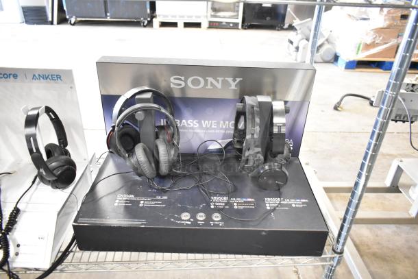 Four headphone displays featuring Sony models, showcasing different styles and features. Appears in good condition.