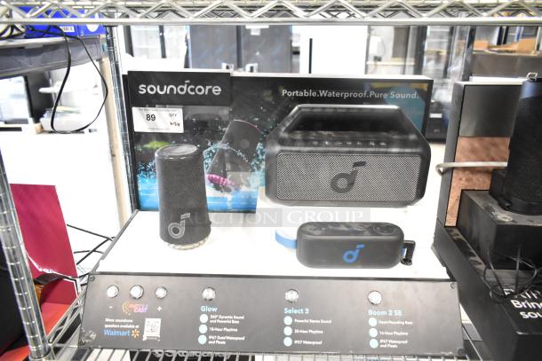 Two store displays featuring Soundcore and Sony speakers, showcasing waterproof and sound quality features. Auction label indicates an opportunity for doubled bids.