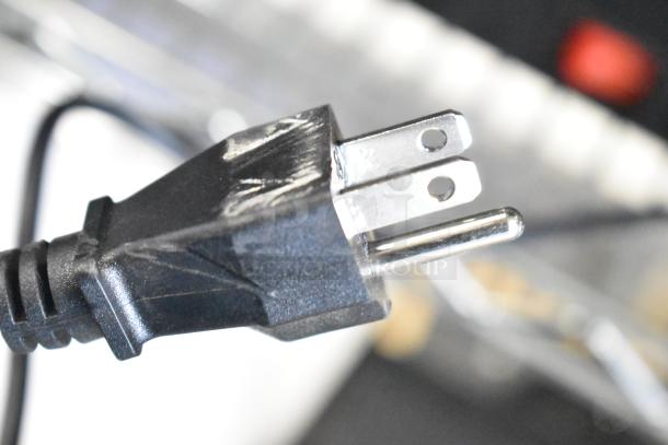 Close-up image of a standard two-prong power plug, highlighting the metal prongs and black plastic casing.