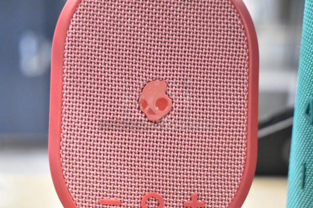 Skullcandy speaker with mesh design and skull logo, part of a store display bundle with Sony headphones and Onn speaker.