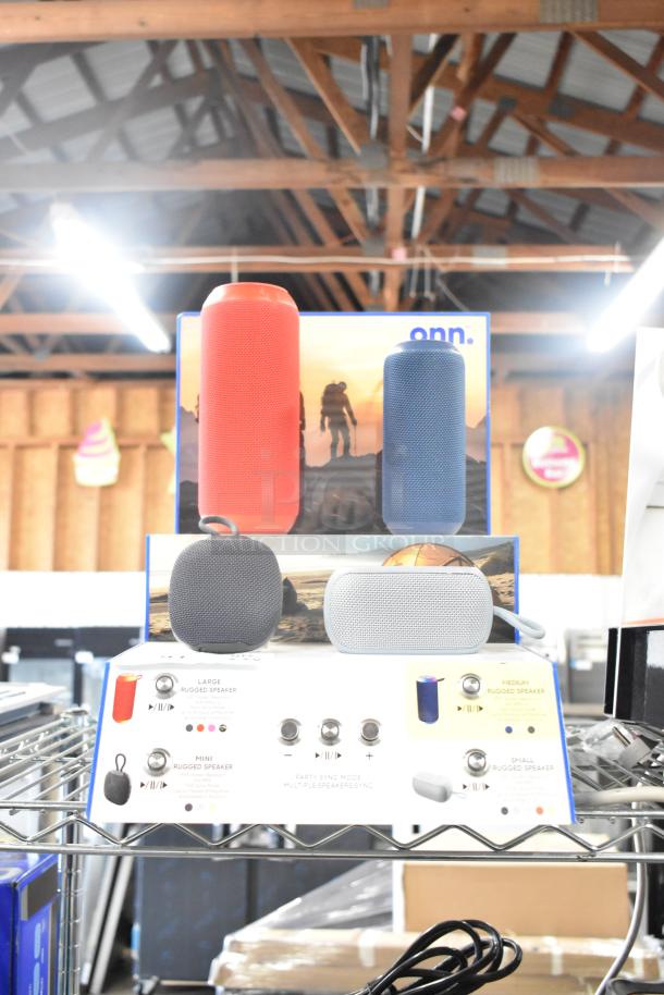 Store display with Sony and JBL headphones, Onn speakers. Various models in vibrant colors highlighting product features.