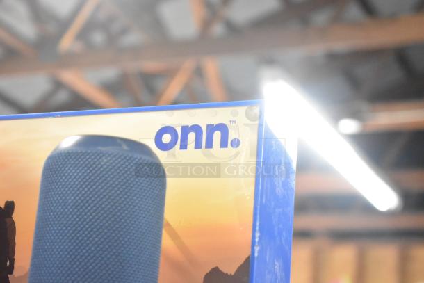 Display box featuring Onn speakers, part of a set with Sony and JBL headphones. Visible brand name and partial speaker image.