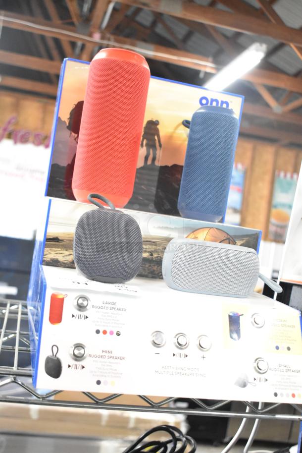 3 store displays featuring Sony headphones, JBL headphones, and Onn speakers. Red and blue rugged speakers on display.
