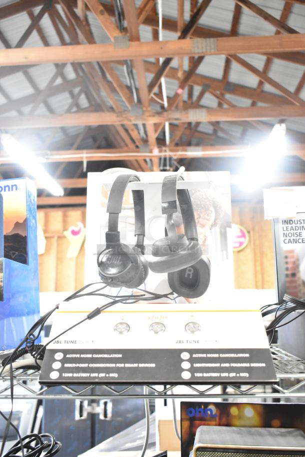 3 store displays with Sony headphones, JBL headphones, and Onn speakers. Labels highlight features like noise cancellation.