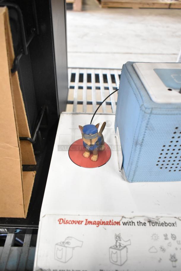 TonieBox display with small character figure on stand. Visible wear. "Discover Imagination with the Toniebox" text.