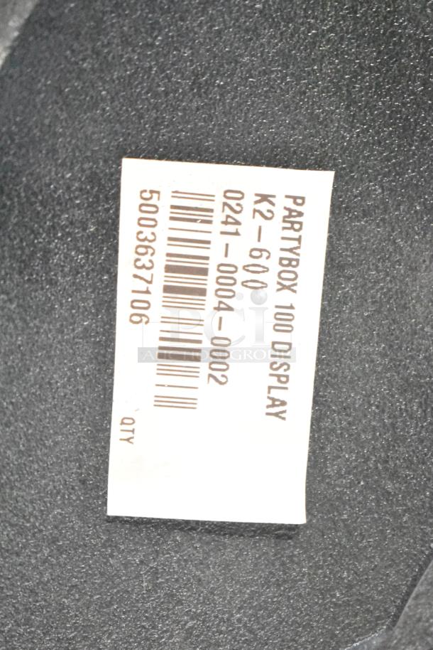 Label showing "Partybox 100 Display, K2-600," with barcode on black textured surface.