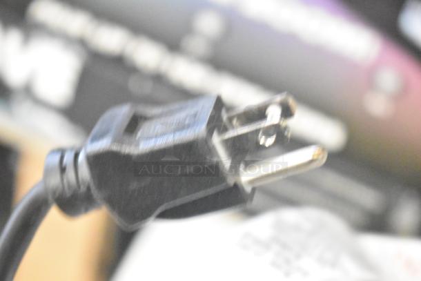 A close-up image of a power plug with a blurred background, not showing speakers.