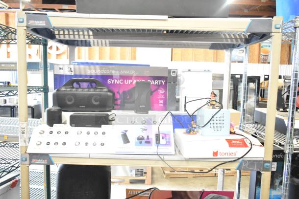 Store displays with TonieBox, Anker Soundcore speaker, Onn speaker, and Sony speaker on shelving unit.