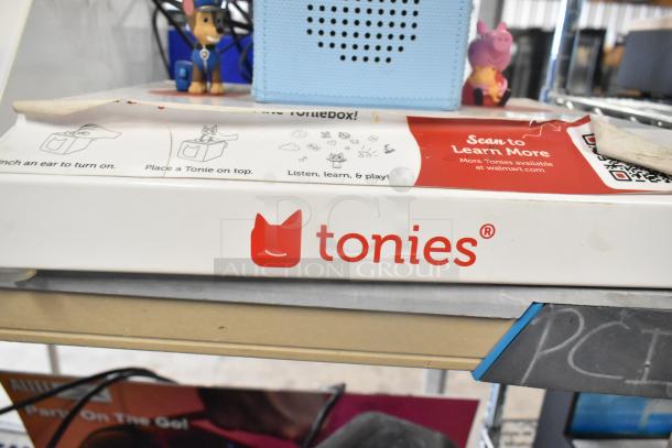 4 store displays featuring TonieBox, Anker Soundcore, Onn, and Sony speakers. Box shows Tonies® logo and instructions.