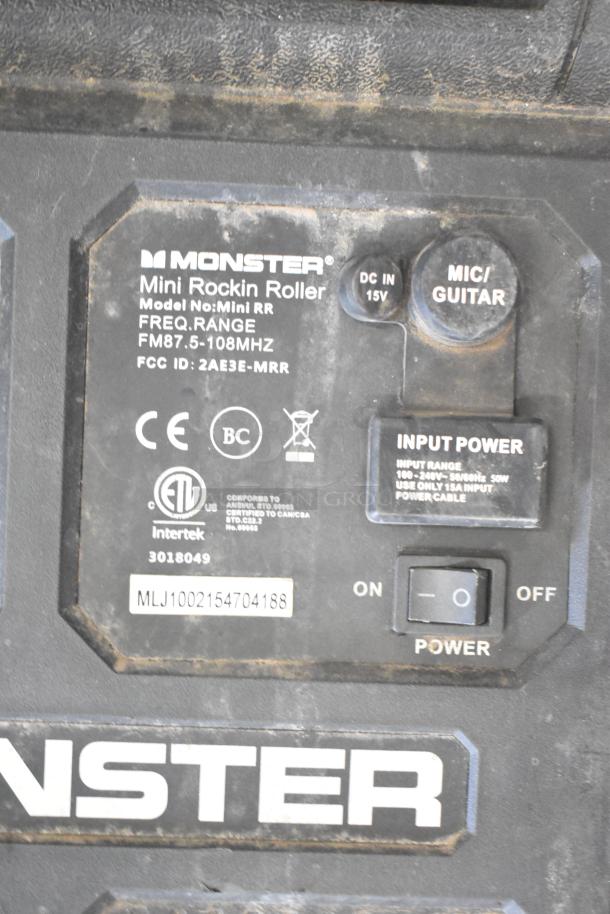 Monster Mini Rockin Roller Speaker with input options and power switch. Labels indicate frequency range and FCC ID. Dusty condition.