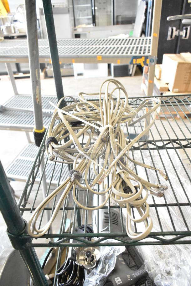 Lot of various items including coiled ethernet cables, metal handle, Motorola walkie-talkie, barcode scanner, and stand.