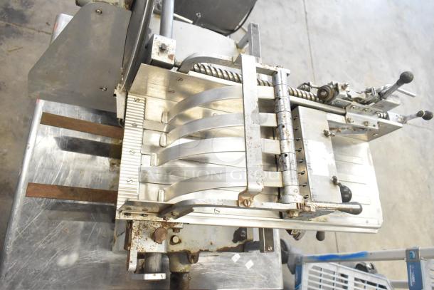 US Berkel commercial countertop flywheel meat slicer on stand, showing metal construction with visible wear and rust.