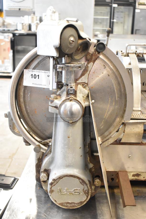 US Berkel commercial countertop flywheel meat slicer on equipment stand, showing visible wear and "U.S. Berkel" marking.