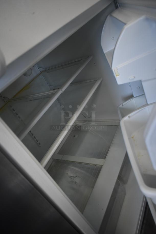 Whirlpool ET1MHKXMQ04 reach-in cooler with freezer, clean interior, 115 volts, 1 phase, shelves visible.