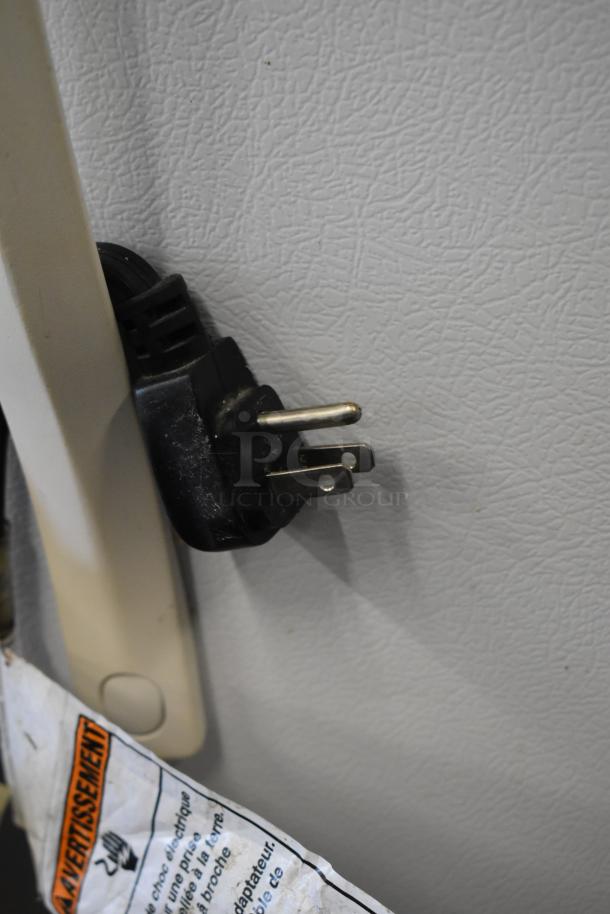 "Whirlpool ET1MHKXMQ04 cooler plug, 115V, 1 phase, beige finish; electrical warning tag visible."