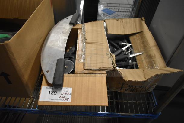 Two boxes containing sharpened stainless steel knives including paring knives, pizza cutters, and a dough cutter. Auction tag reads "QTY x 2 boxes APX x 48".