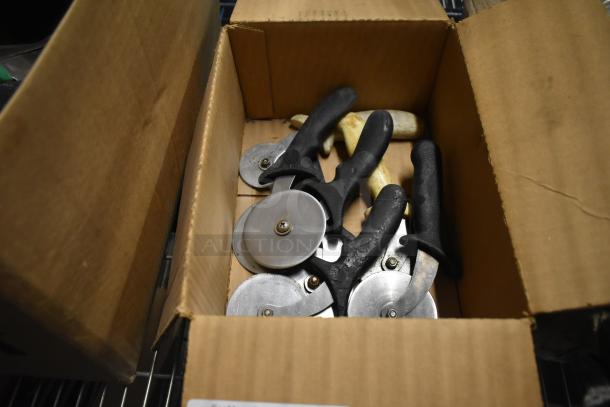 Box of stainless steel pizza cutters with black handles, various sizes.