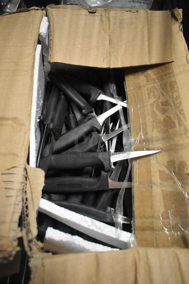 Open box containing mixed stainless steel knives, including paring knives and pizza cutters, with black handles.