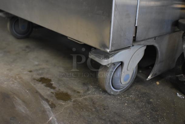 LATE MODEL JBT 2ND-GEN-MFJ-HE citrus juicer on commercial casters, stainless steel, 115V, 1 phase, industrial setting.