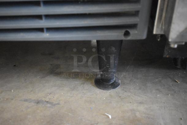 Close-up of a Scotsman Commercial self-contained undercounter ice maker's black leg on a concrete floor.