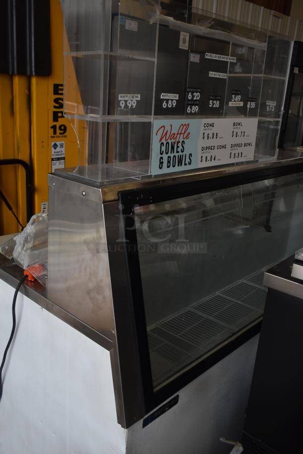Master Bilt commercial ice cream dipping cabinet, stainless steel, glass front, pricing labels visible. 