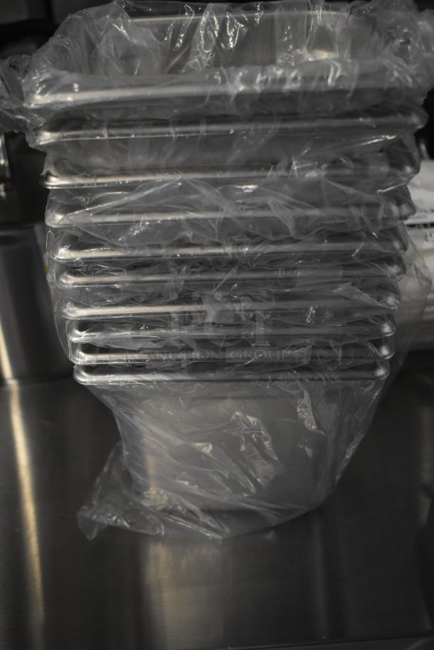 Stack of new stainless steel drop-in bins wrapped in plastic, part of 13-item scratch and dent auction lot.