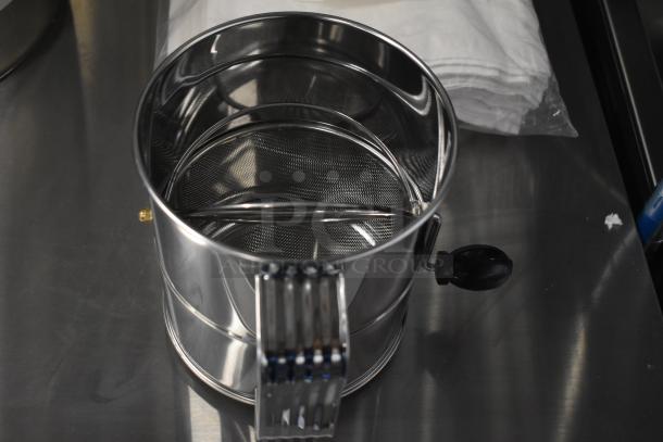 Stainless steel flour sifter with handle, new condition. Part of a 13-piece scratch and dent auction lot.