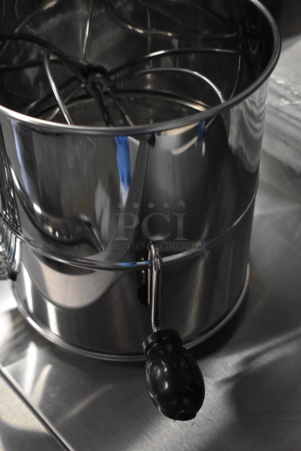 Metal flour sifter with black handle, part of a 13-item scratch and dent auction lot including bins and flour sack.
