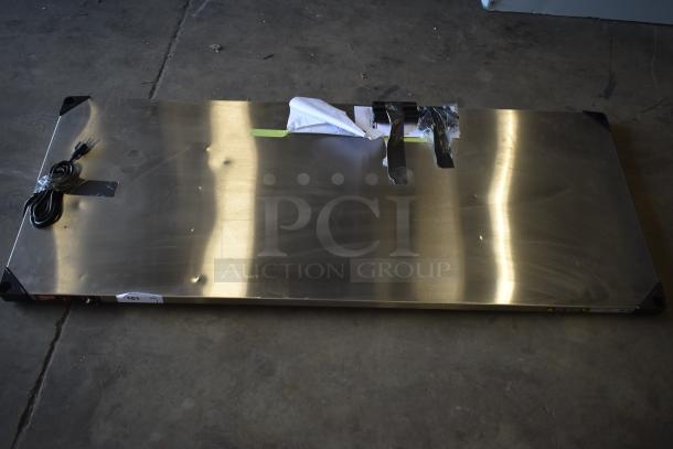 Metro Super Erecta Hot HS2460 stainless steel heated shelf, 24"x60", 120V, new with dents, visible packaging tape.