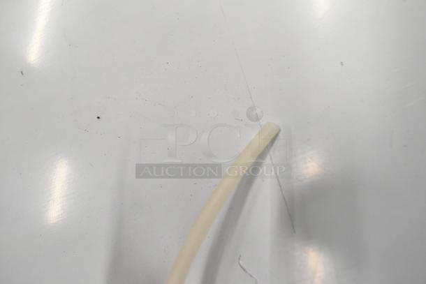 Close-up of a white tube on a reflective surface, possibly detailing a component of the Scotsman CU0415MA-1A ice machine.