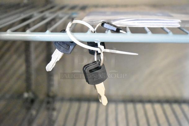 Keys attached with a zip tie on the interior shelf of an Avantco 178UBB72GHC refrigerator.