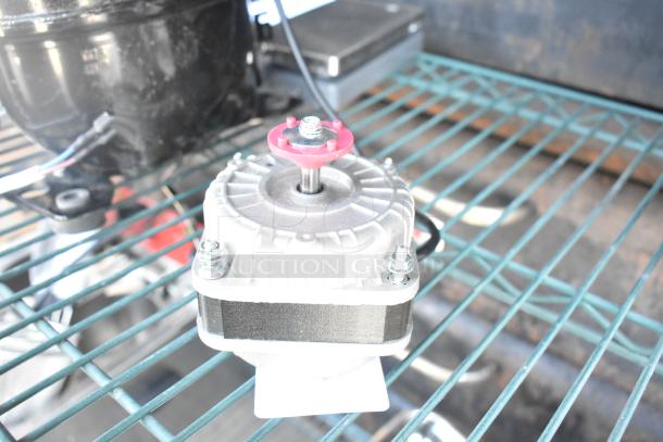 Brand new Avantco 17810032 fan motor, scratch and dent condition, visible mounting hardware, compact design.