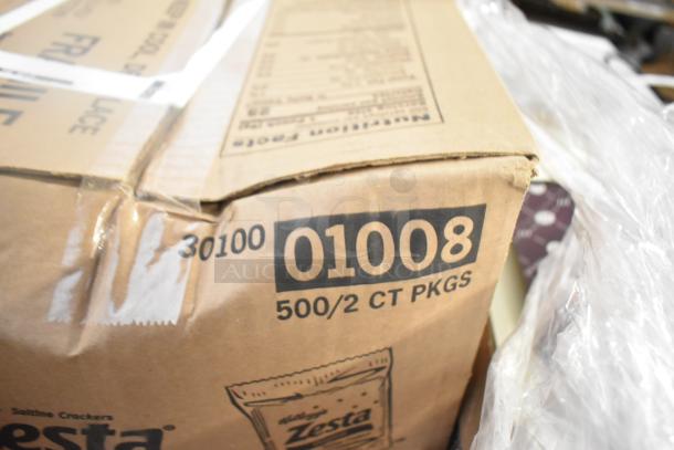 Cardboard box of Zesta Saltine Crackers, labeled "500/2 CT PKGS, 01008," indicating bulk packaging.