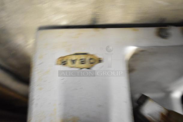 Blurry close-up showing a part of a Hobart 1612 Commercial Countertop Meat Slicer with visible wear.