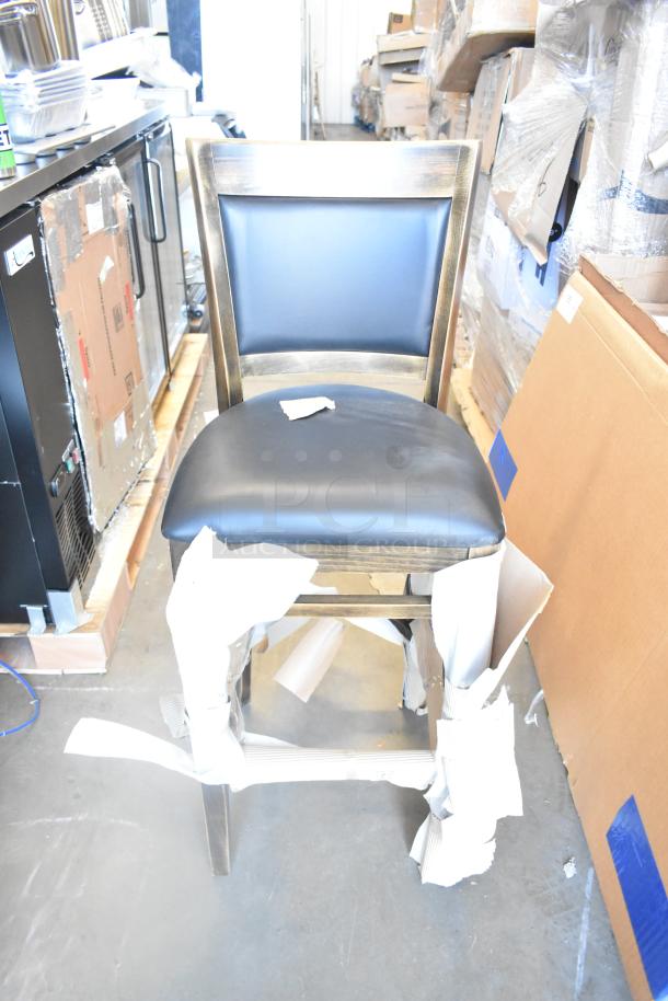 Brand new chair with dark wood finish and black cushioned seat, partially wrapped. Appears pristine with minor packaging.