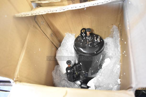 Box containing black cylindrical item wrapped in bubble wrap, part of 18 new scratch-and-dent auction items.