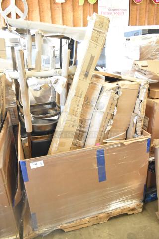Pallet with brand new scratch and dent items, including chairs and outdoor table, visible box labels and protective wrap.