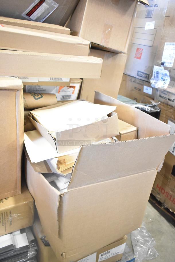 Cardboard boxes containing various scratch and dent items like merchandise bags, folders, Dixie napkins, and floor stand. Boxes show wear.