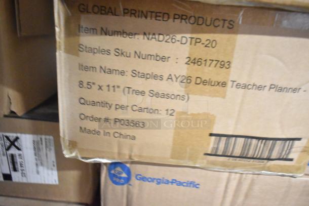 Cardboard box of Staples AY26 Deluxe Teacher Planners, 8.5"x11", 12 per carton, marked "Made in China," with barcodes.