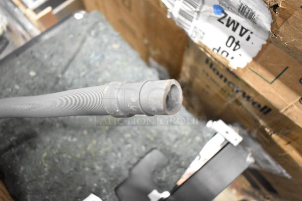 Honeywell HDS18B 18" Dishwasher, 120 Volts, 1 Phase, visible drain hose, and parts. Packaging shows Honeywell branding.