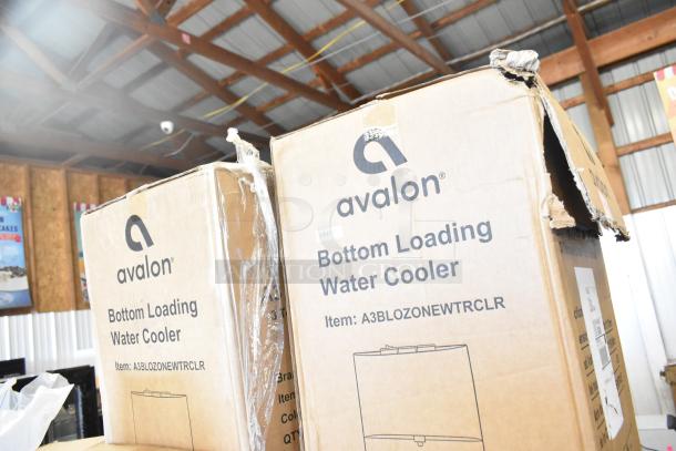 Two boxed Avalon A3BLOZONEWWTRCLR self-cleaning water coolers, labeled "scratch and dent," in stock photo.