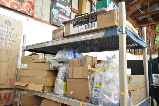 Two-tier shelf with desk calendars, Lysol cleaner, wire glove box holder, Purell soap, Coastwide hand soap, various boxes.